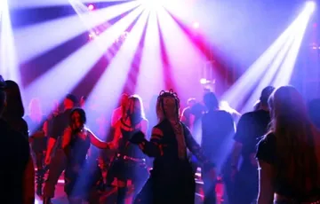 Une piste de danse animée avec des gens qui dansent sous des lumières de scène colorées